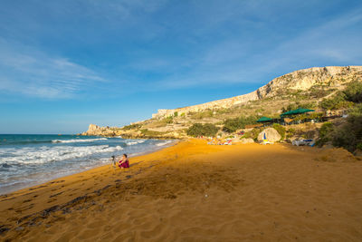 Scenic view of beach against blue sky