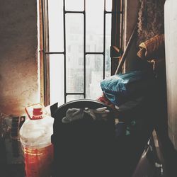 Close-up of bottle against window at home