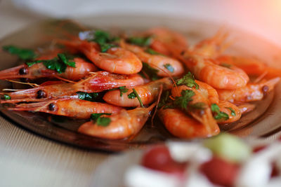 Delicious prawns with coriander in a plate on the table. fresh seafood dish close-up.