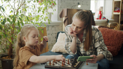 Mother playing chess with daughter