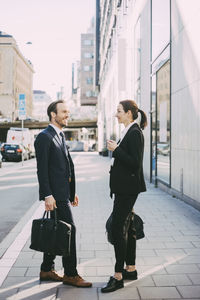 Side view of business people standing on sidewalk