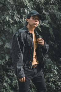 Young man looking away in forest