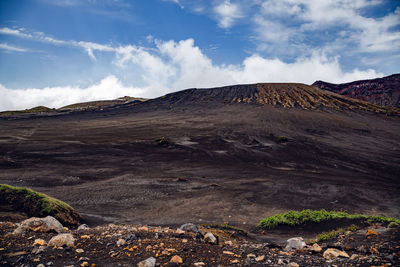 View on a black soil and rocks in the volcanic landscape near to aso mountain in kyushu, japan