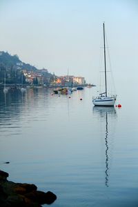 Sailboat moored in sea against sky