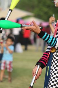 Midsection of clown juggling pins