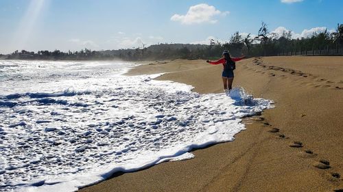 Full length of man on beach against sky during winter