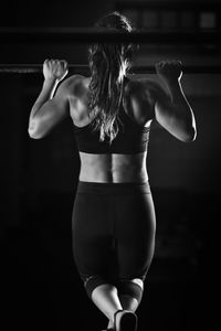 Rear view of woman exercising at gym