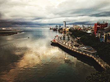 Boats in sea against cloudy sky