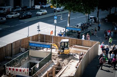 High angle view of people walking on city street by construction site