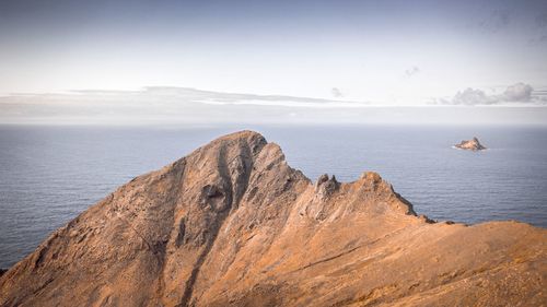 Scenic view of rocks in sea against sky