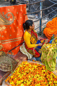 Rear view of man with orange flowers in market