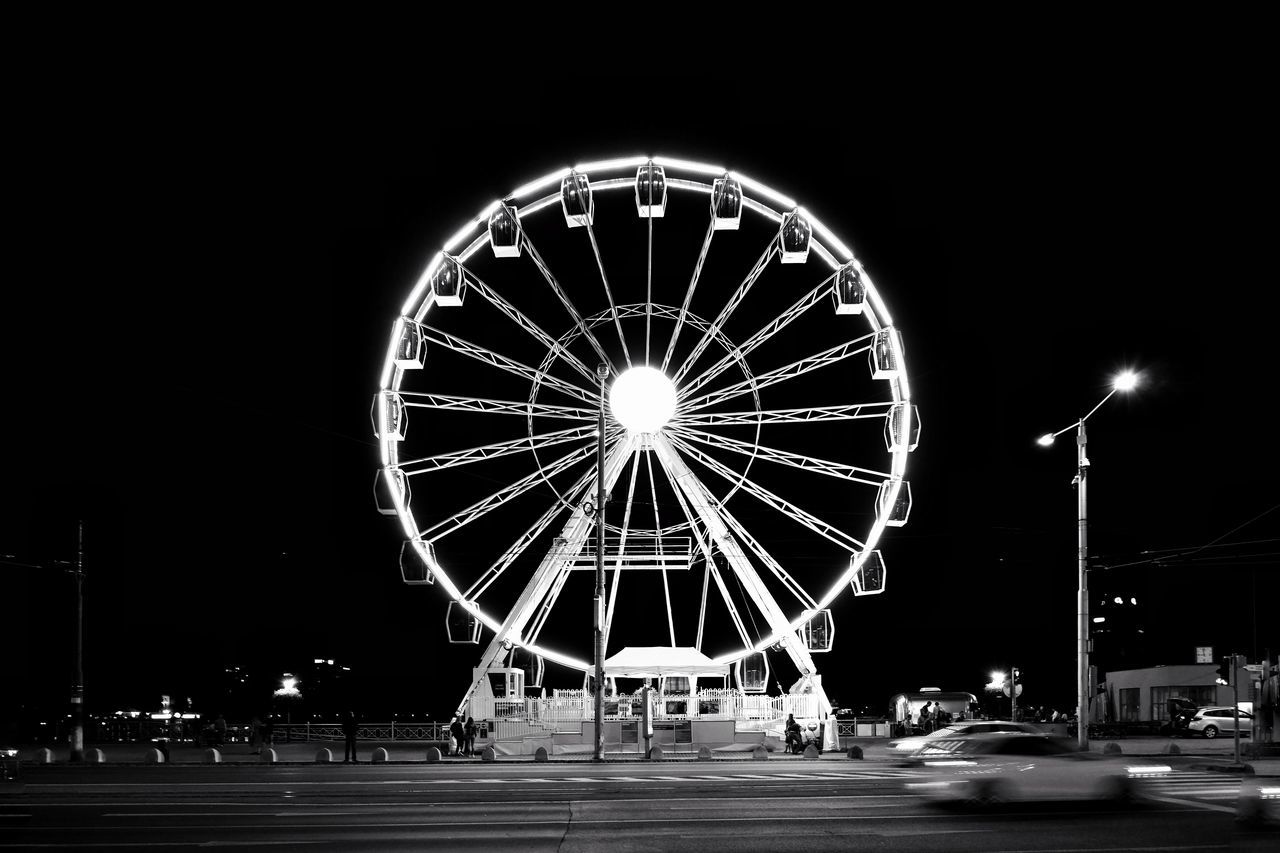 ILLUMINATED FERRIS WHEEL AGAINST SKY AT NIGHT