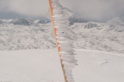 Snow covered land and mountains against sky