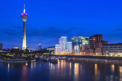 Illuminated buildings in city at waterfront