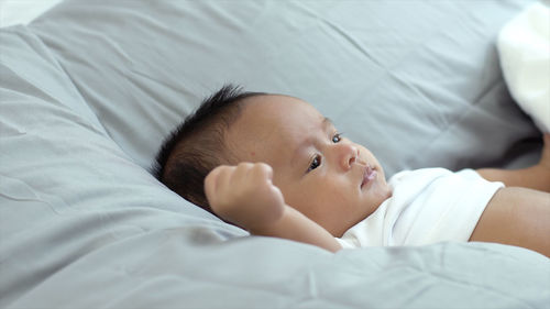 Cute baby lying on bed at home