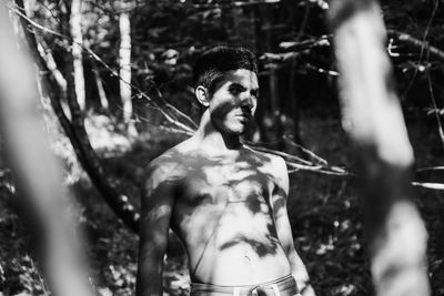 Portrait of young man standing in forest