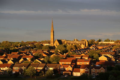 Buildings in town against sky during sunset