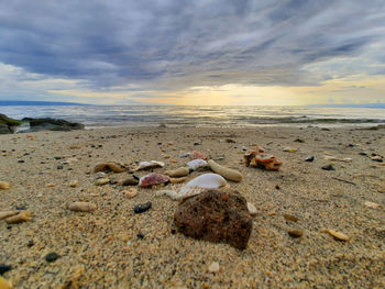 Surface level of beach against sky during sunset