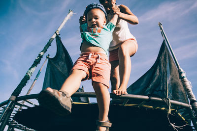 Low angle view of girl on boat against sky