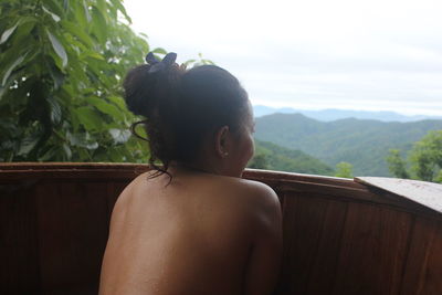 Rear view of naked woman looking at view