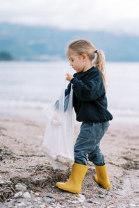 Side view of boy standing at beach