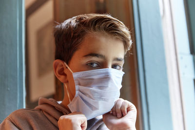 Close-up portrait of boy wearing mask at home