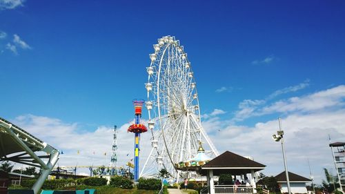 Low angle view of ferris wheel against blue sky