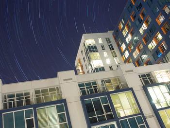 Low angle view of illuminated buildings against clear sky at night