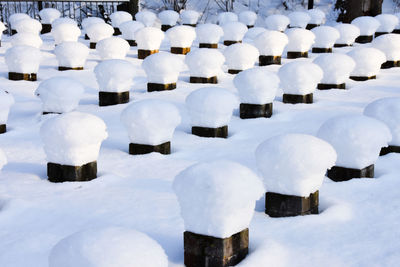  benches in park, seating part removed due to construction, symmetrical piles of bricks. winter time.