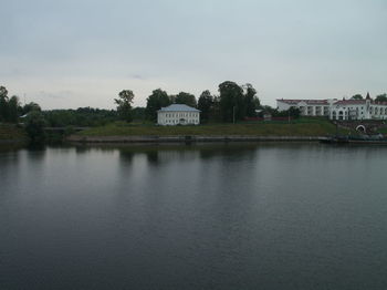 View of building by lake against sky