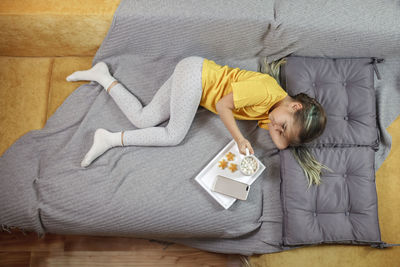 High angle view of girl lying on bed at home