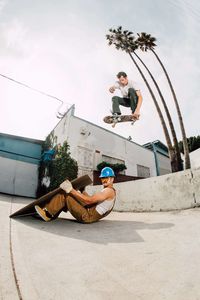 Young couple in front of built structure against sky