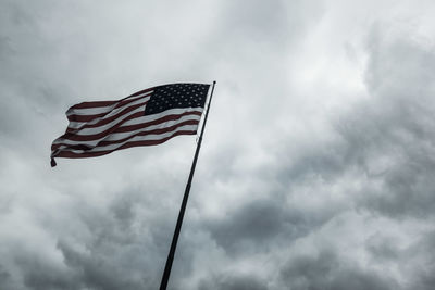 Low angle view of american flag against cloudy sky