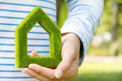 Close-up of woman holding grass home