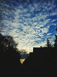 Silhouette of trees against cloudy sky