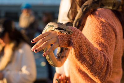 Close-up mid section of woman holding python