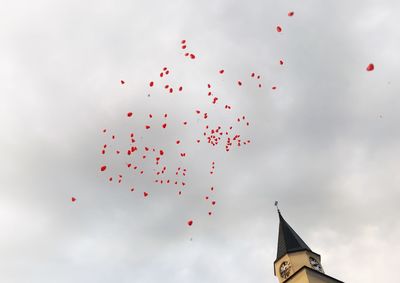 Low angle view of balloons flying against sky