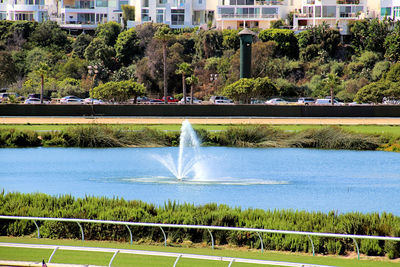 Water fountain in city against sky