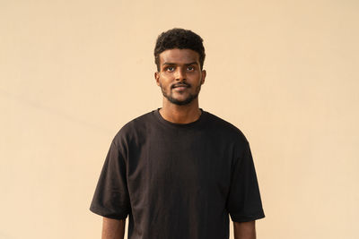Portrait of handsome young african man wearing oversized black t-shirt
