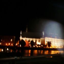 Road passing through illuminated city at night
