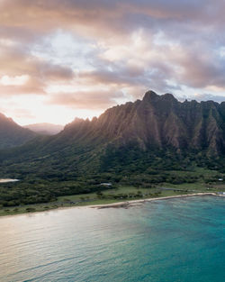 Scenic view of sea and mountains against sky