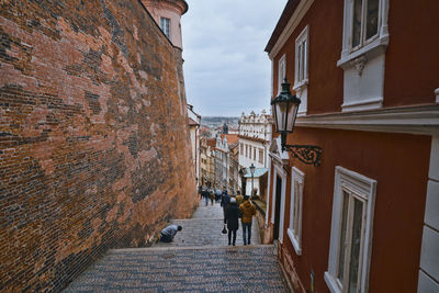 People walking on street amidst buildings in city