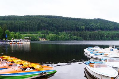 Boats moored in lake against sky