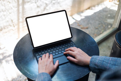 Midsection of woman using digital tablet