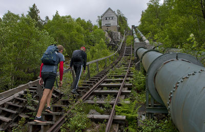 People on railroad tracks against sky