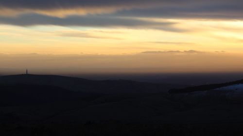 Scenic view of silhouette mountains against sky during sunset