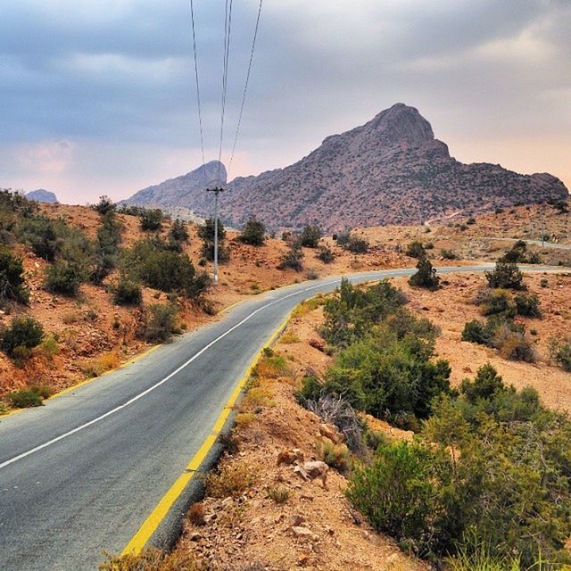 mountain, the way forward, road, sky, transportation, landscape, tranquil scene, tranquility, mountain range, country road, diminishing perspective, scenics, electricity pylon, power line, nature, non-urban scene, cloud - sky, beauty in nature, countryside, tree