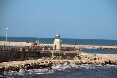 Trani,  italy, 4 december 2022, the lighthouse seen from the hanging garden on the sea