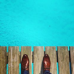 Low section of man standing by swimming pool