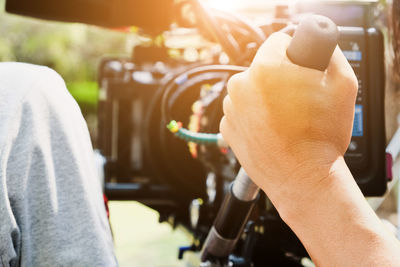 Cropped image of man using video camera on sunny day